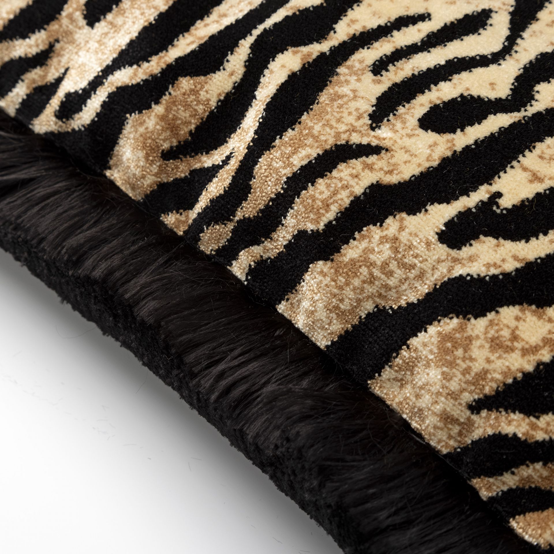 Detail tijgerprint sierkussen met een luxe franje rand
